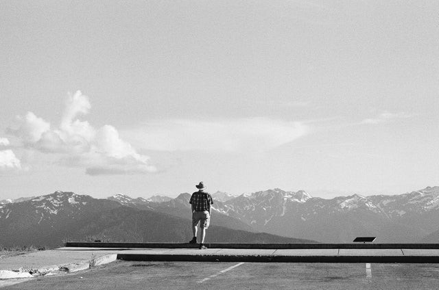 Old man watching mountains far away.